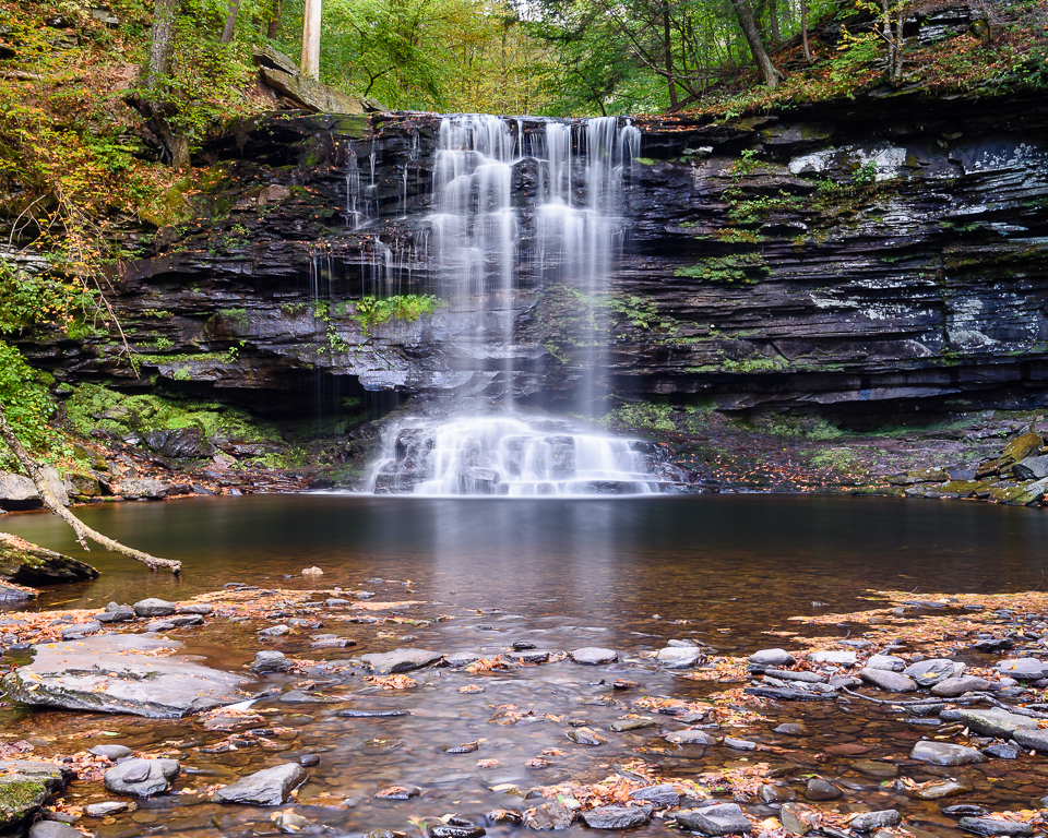 A waterfall cascades over a shale shelf.