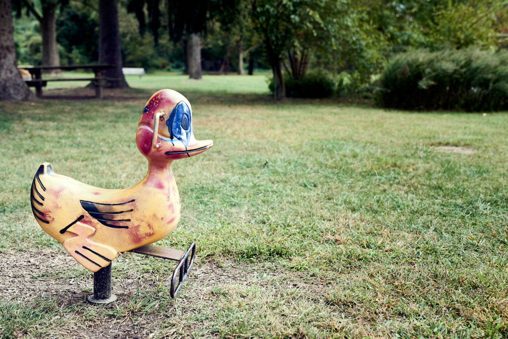 A color photograph of a playground duck that has been spray painted.