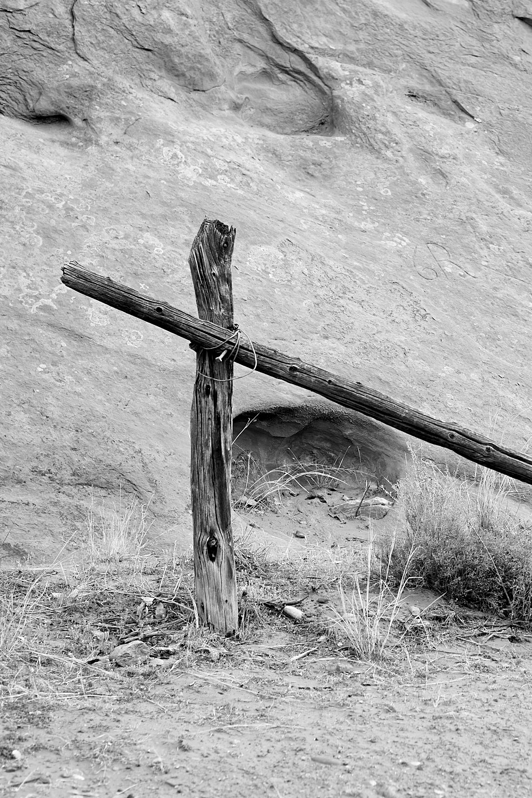 Landscape #220513.1. A black and white photo of an old corral post against a sandstone cliff.