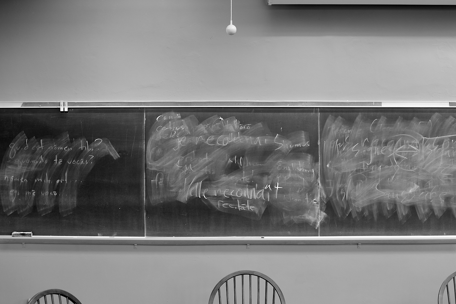 #220831: Black and white image of a blackboard with writing mostly erased.