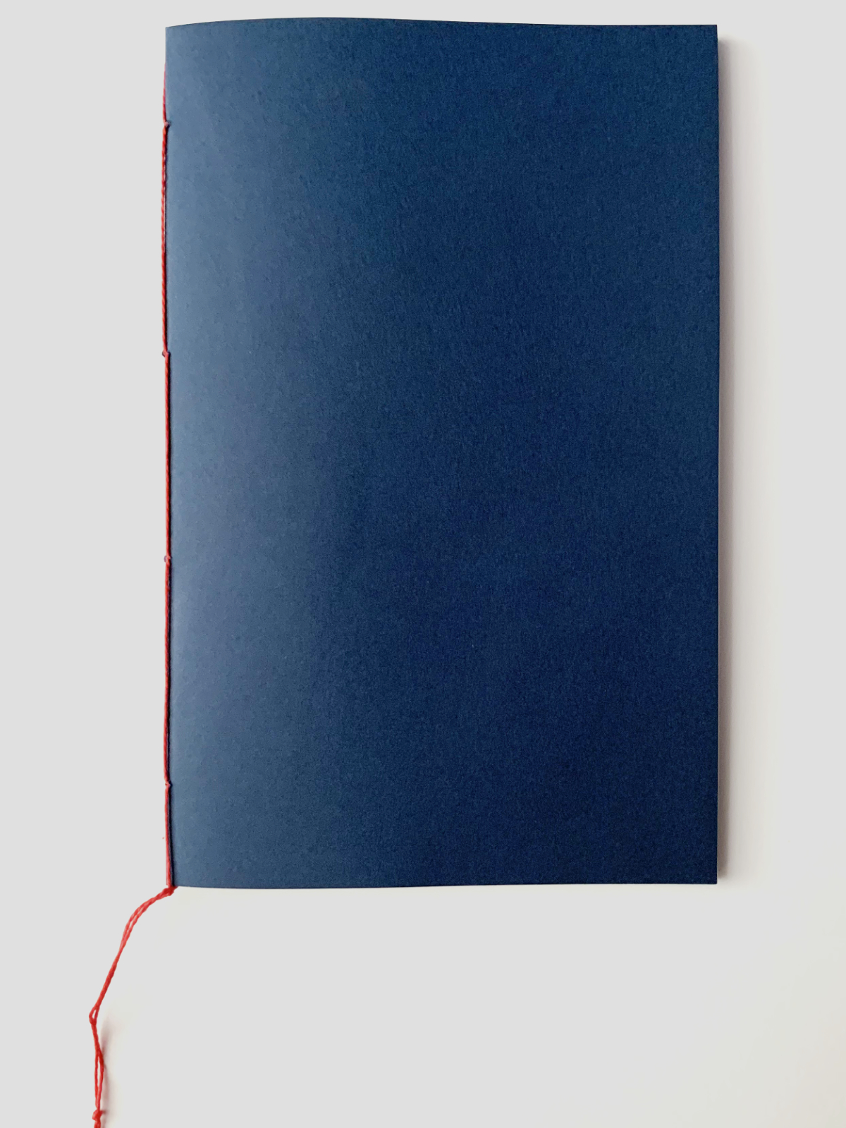 Photo of the cover of the pamphlet, showing red binding thread.