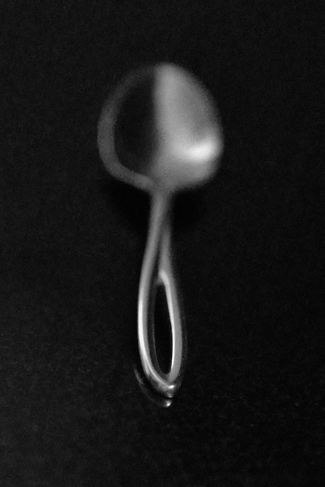 Still Life #230417. A spoon on a dark surface.