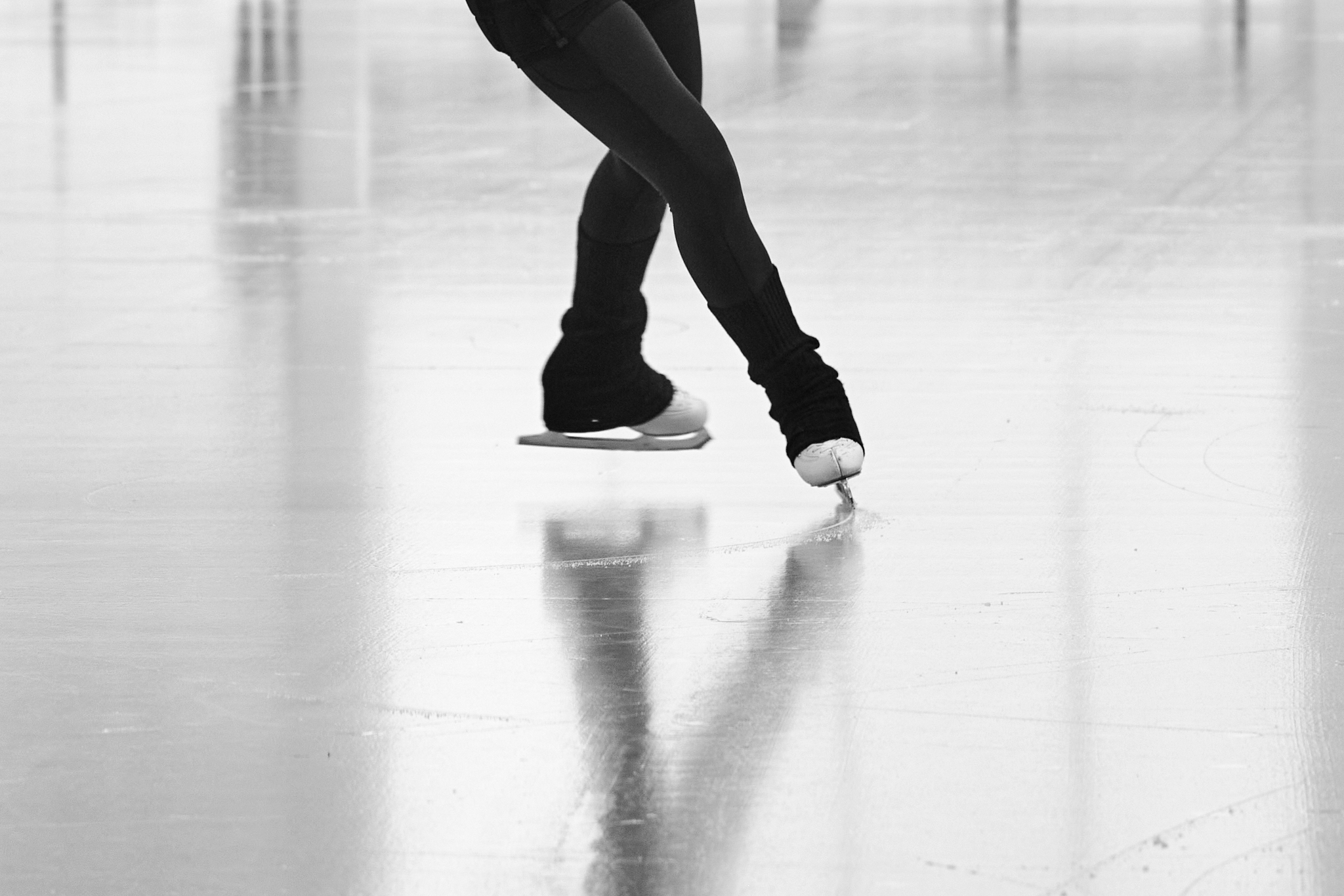 Urban #230727.1. Black and white photograph of a person ice skating showing just the skates on the ice.