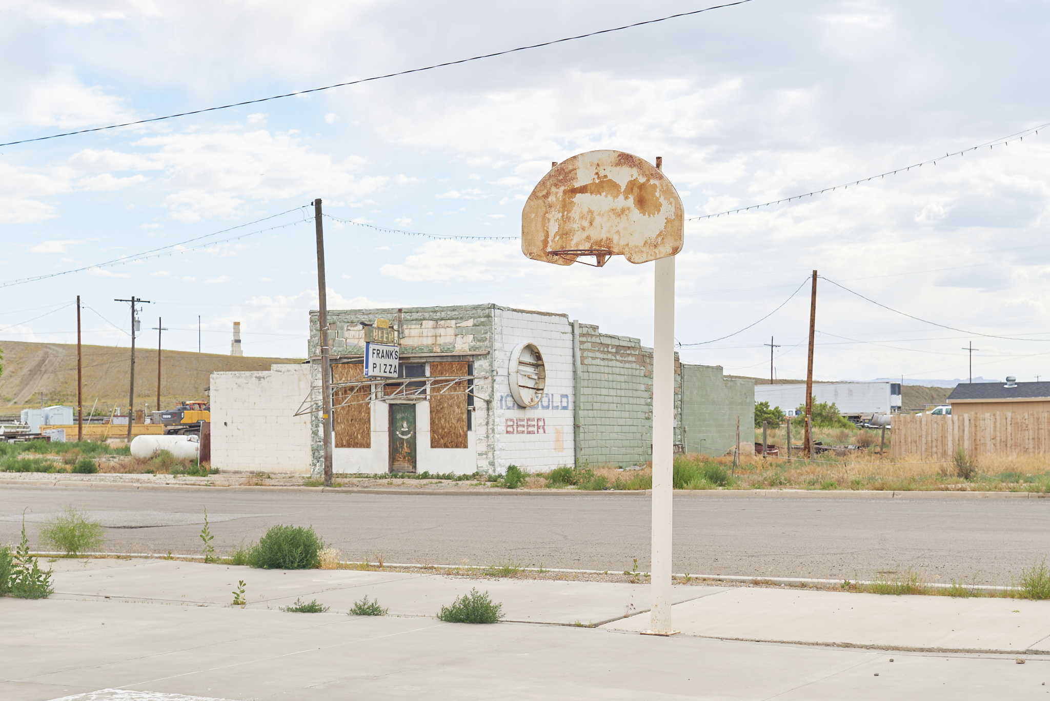 Urban #230611. A color photograph showing a basketball hoop and a derelict building.