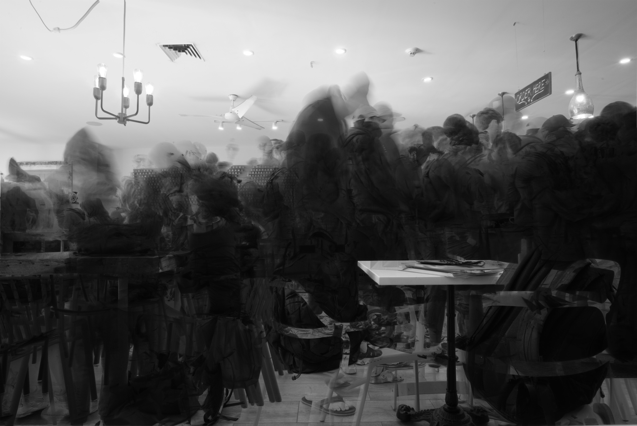 Urban #230917. A black and white photograph of ghostly images in a cafe.