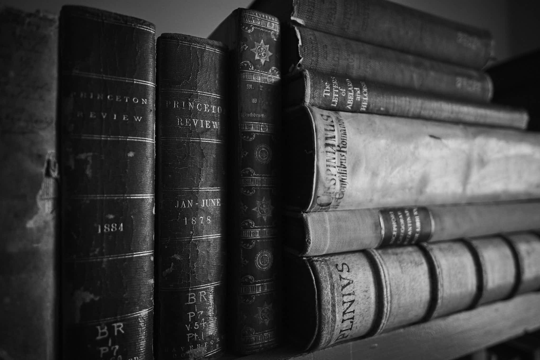 Still life #240331.2. A black and white photograph of old books on a shelf.