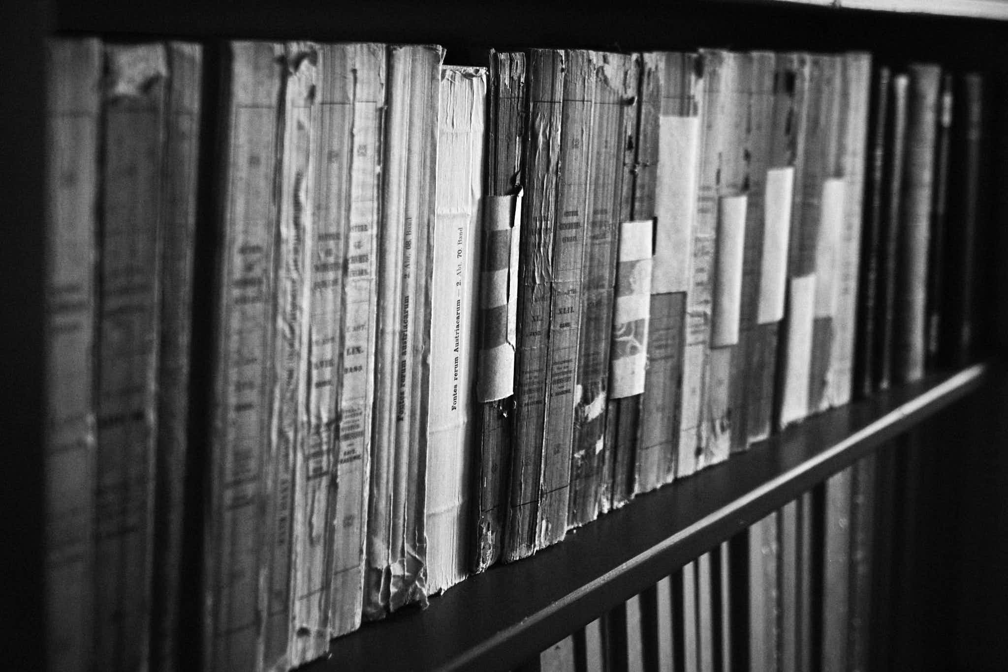 Still life #240331.3. A black and white photograph of old books on a shelf.