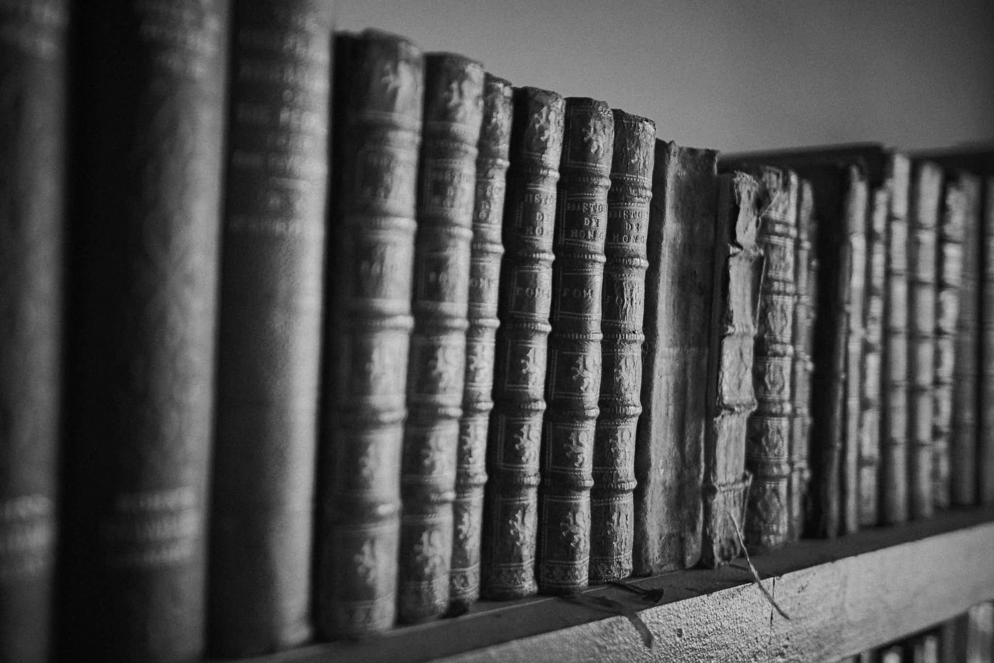 Still life #240331.4. A black and white photograph of old books on a shelf.