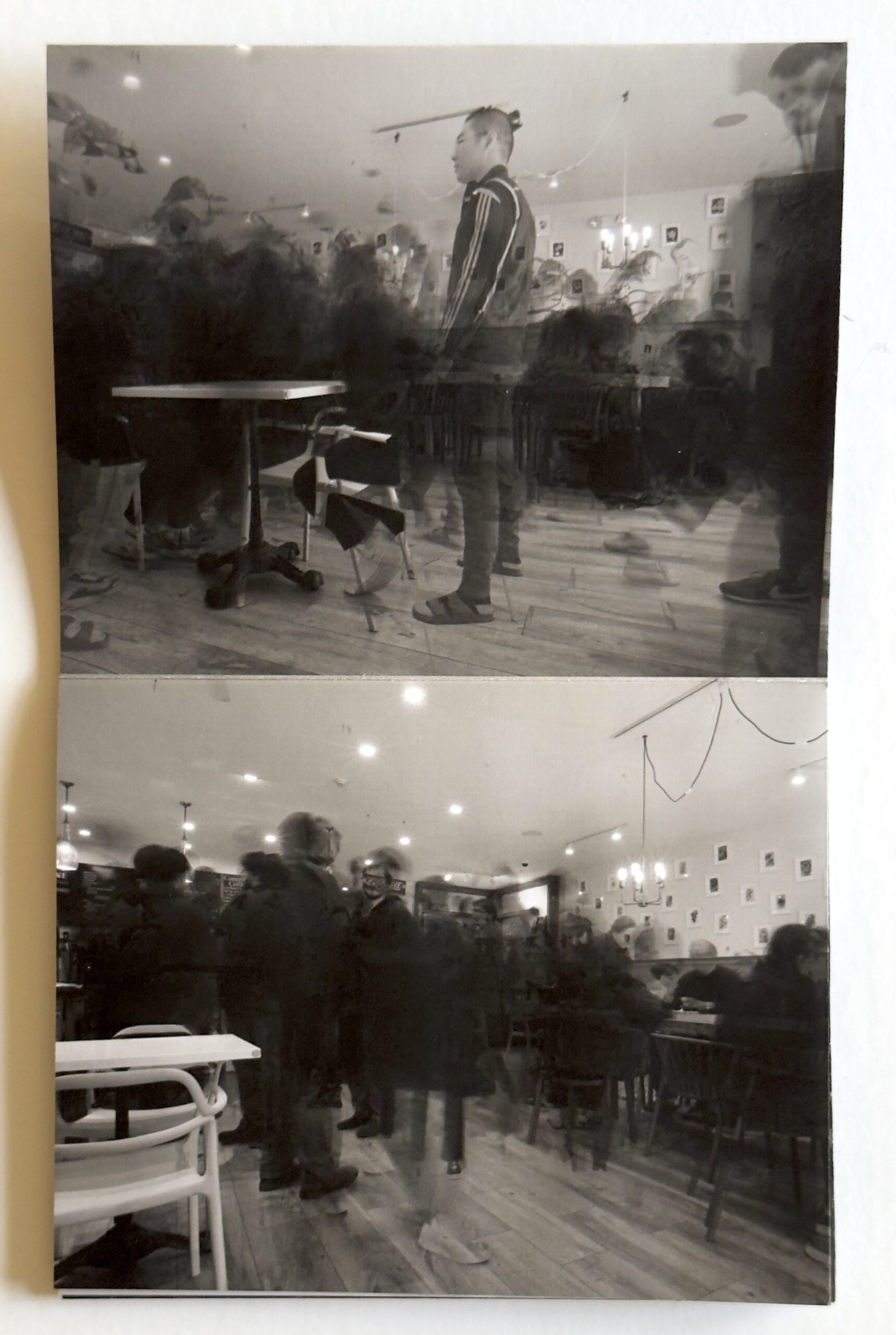 Black and white photograph of a spread from the “Ephemeral” zine, showing ghost like figures is a cafe.